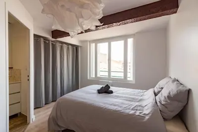 a bedroom with a bed and a large window at Charmant duplex Castelnaudary in Castelnaudary