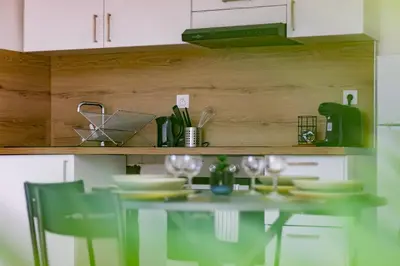 a table with chairs and plates on it in a kitchen at Charmant duplex Castelnaudary in Castelnaudary