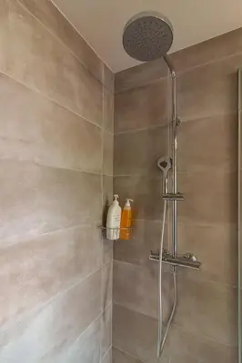 a shower with a shower head in a bathroom at Charmant duplex Castelnaudary in Castelnaudary