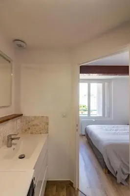 a bedroom with a bed and a bathtub and a sink at Charmant duplex Castelnaudary in Castelnaudary