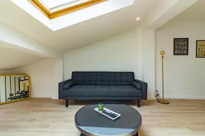 a living room with a couch and a table at Charmant duplex Castelnaudary in Castelnaudary
