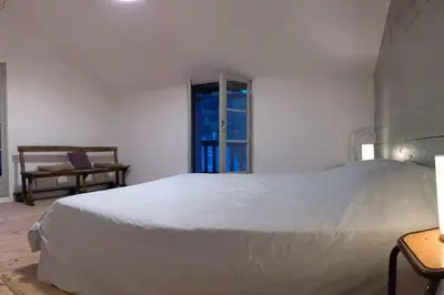 a bedroom with a large white bed and a window at Grand gîte au cœur des Pyrénées - Ariège Mijanes in Mijanès