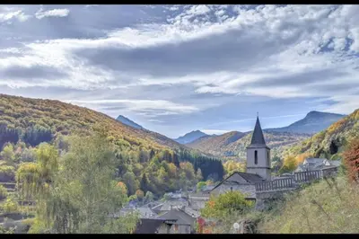 a church in the middle of a valley with trees at Grand gîte au cœur des Pyrénées - Ariège Mijanes in Mijanès