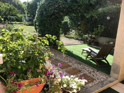 a garden with a bench and some flowers at chambre et salle de bain privé s'ouvrant sur terrasse, jardin et cuisine d'été in Quillan