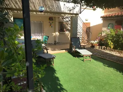 a yard with two chairs and a lawn withgrass at chambre et salle de bain privé s'ouvrant sur terrasse, jardin et cuisine d'été in Quillan