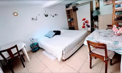 a bedroom with a bed and a table and chairs at chambre et salle de bain privé s'ouvrant sur terrasse, jardin et cuisine d'été in Quillan