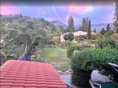 a large red roof with a rainbow in the background at chambre et salle de bain privé s'ouvrant sur terrasse, jardin et cuisine d'été in Quillan