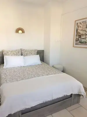 a white bedroom with a large bed in a room at Plage des Chalets appartement T2+terrasse in Gruissan