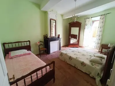 a bedroom with two beds and a mirror at Maison de village 8 couchages in La Livinière