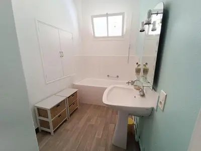 a bathroom with a sink and a tub and a mirror at Maison de village 8 couchages in La Livinière