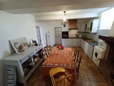 a kitchen with a table and chairs in a kitchen at Maison de village 8 couchages in La Livinière