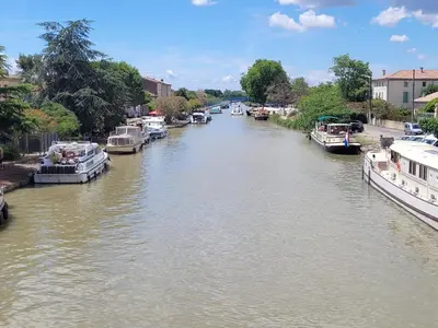 a river with boats docked on the sides of it at Casa Allègre in Aigne