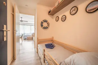 a room with a bed and clocks on the wall at L'Escale de la Plage in Gruissan
