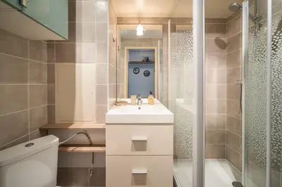 a bathroom with a toilet and a sink and a shower at L'Escale de la Plage in Gruissan