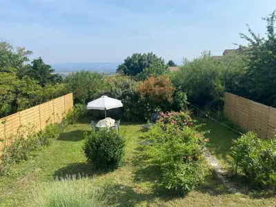 a garden with an umbrella and some bushes at Maison de village in Fanjeaux