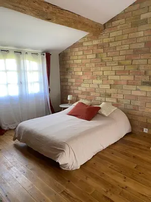 a bedroom with a brick wall and a bed at Maison de village in Fanjeaux