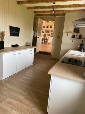 a kitchen with white cabinets and a counter top at Maison de village in Fanjeaux