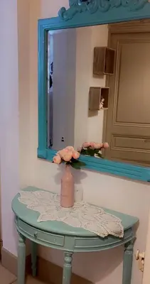 a bathroom with a mirror and a table with a vase at Appartement T3 centre ville in Narbonne