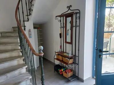 a hallway with a stair case with baskets and a mirror at Grande Maison Vigneronne, proche de la mer in Salles-d'Aude