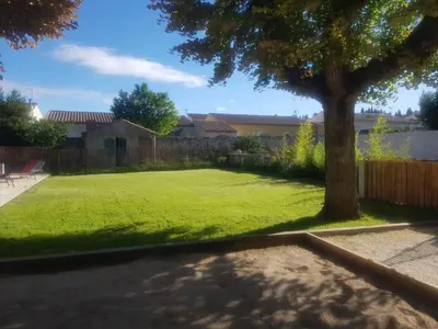 a yard with a tree and a fence at Grande Maison Vigneronne, proche de la mer in Salles-d'Aude