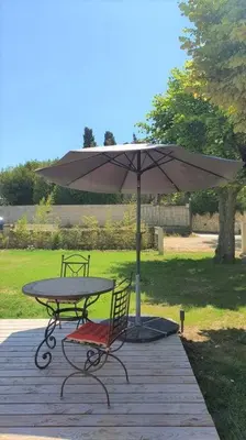 a picnic table and an umbrella on a deck at Grande Maison Vigneronne, proche de la mer in Salles-d'Aude