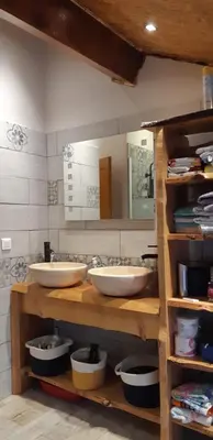 a bathroom with two sinks and a mirror at Maison proche de la nature in Quérigut