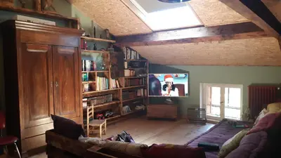 a living room with a couch and a tv at Maison proche de la nature in Quérigut