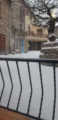 a house with a blue door in the snow at Maison proche de la nature in Quérigut