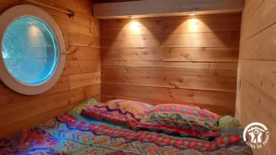a room with two pillows on a bed with a window at Terra bosca roulotte in Cambounès