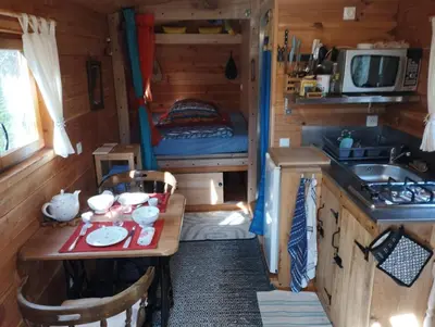 a small kitchen with a table in a tiny house at Terra bosca roulotte in Cambounès