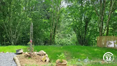 a yard with a garden with a plant in the grass at Terra bosca roulotte in Cambounès