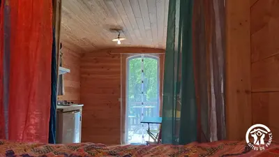 a room with curtains and a window in a bedroom at Terra bosca roulotte in Cambounès