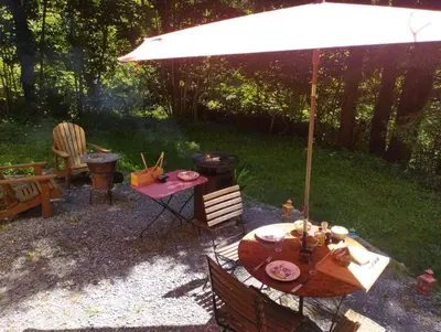 a picnic table and an umbrella in a backyard at Terra bosca roulotte in Cambounès