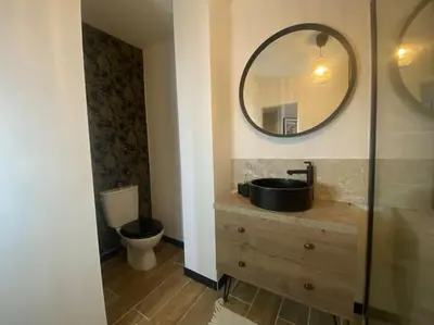 a bathroom with a sink and a mirror and a toilet at White Wood in Narbonne