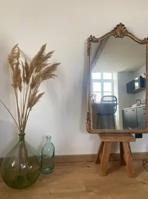 a vase sitting on a table with a mirror at White Wood in Narbonne