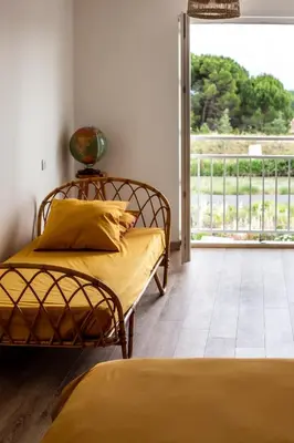two beds sitting in a room with a balcony at Maison avec piscine, vue sur le Canal du Midi in Capestang