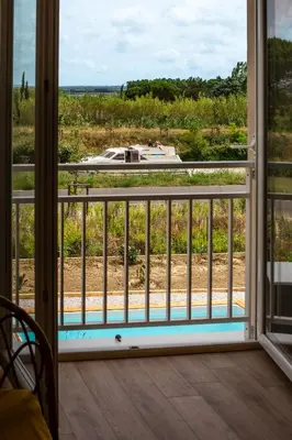a view from a window of a pool at Maison avec piscine, vue sur le Canal du Midi in Capestang