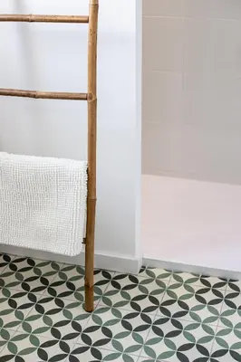 a bathroom with a black and white floor and a towel at Maison avec piscine, vue sur le Canal du Midi in Capestang