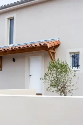 a white house with a door and a tree at Maison avec piscine, vue sur le Canal du Midi in Capestang