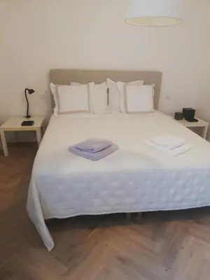 a large white bed with two towels on it at Les 3 Platanes in Conilhac-Corbières