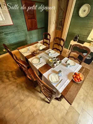 a wooden table with plates and bowls of fruit on it at Les 3 Platanes in Conilhac-Corbières