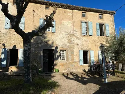 a shadow of a person sitting in front of a building at Les 3 Platanes in Conilhac-Corbières