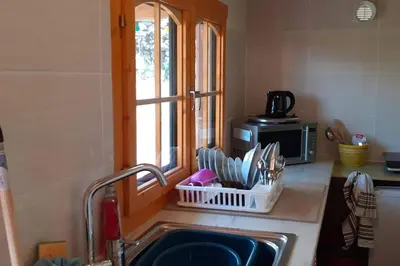 a wooden porch of a house with a deck at LOU CABANOT CHALET DE JARDIN CALME ET CONFORTABLE in Lastours