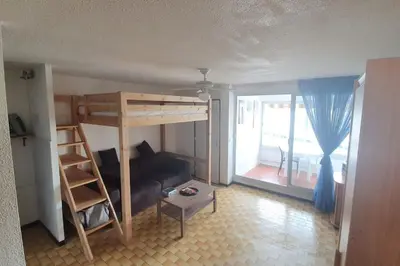 a room with a bunk bed and a couch at Appart. calme 5 Pers vue sur le port de gruissan in Gruissan
