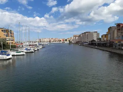 a river with boats docked in a city with buildings at Appart. calme 5 Pers vue sur le port de gruissan in Gruissan
