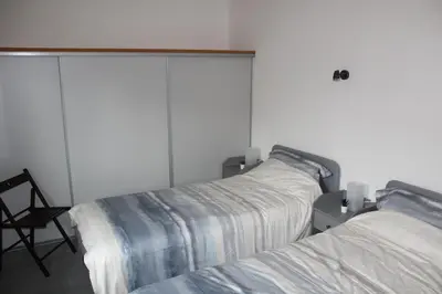 a bedroom with two beds and a chair at 2 bedroom home with shared pool in lovely market town of Olonzac in wine region in Olonzac