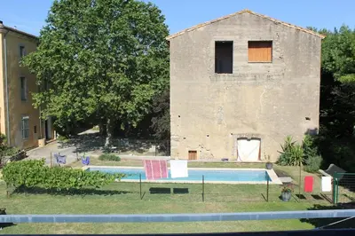 a swimming pool in front of a building at 2 bedroom home with shared pool in lovely market town of Olonzac in wine region in Olonzac