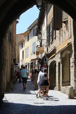 a group of people walking down a narrow street at 2 bedroom home with shared pool in lovely market town of Olonzac in wine region in Olonzac