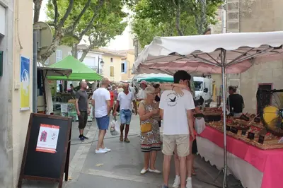 a group of people standing in front of a food stand at 2 bedroom home with shared pool in lovely market town of Olonzac in wine region in Olonzac