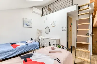 a bedroom with two beds and a staircase at La Remise des Amis - Proche du centre du village in Peyriac-de-Mer